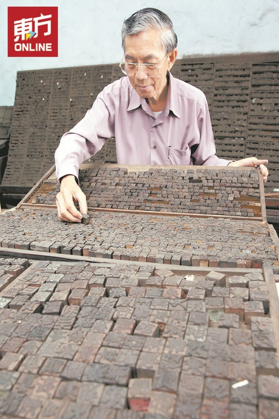 苏国华展示最早期使用的木刻活字印刷。（摄影：刘维杰）